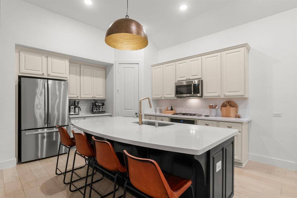 The kitchen’s sleek, clean lines make a striking impression, complemented by a timeless subway tile backsplash that adds both style and practicality. A spacious corner walk-in pantry keeps appliances and essentials neatly tucked away, while the large single-basin sink with pull-out sprayer ensures effortless cleanup. Thoughtful design details—like Rejuvenation hardware and a Crate & Barrel dome light—add the perfect finishing touches to this sophisticated culinary space.