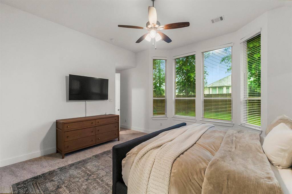 This expansive Owner’s suite offers a perfect blend of elegance and seclusion. Thoughtful details include 6-inch baseboards, plush carpeting, a gently sloped ceiling, direct access to the luxurious en-suite bath, and a lighted ceiling fan for added comfort.