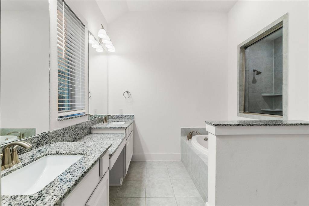 Your Owner’s en-suite is a serene sanctuary designed for ultimate relaxation. From the moment you enter, you’re greeted by elegant tile flooring, a luxurious soaking tub, a large shower, and soft natural light filtering through the window. Thoughtful touches include dual vanities, a private water closet, a spacious walk-in wardrobe, an additional linen closet, and recessed lighting—all combining to create a spa-like retreat within your own home.