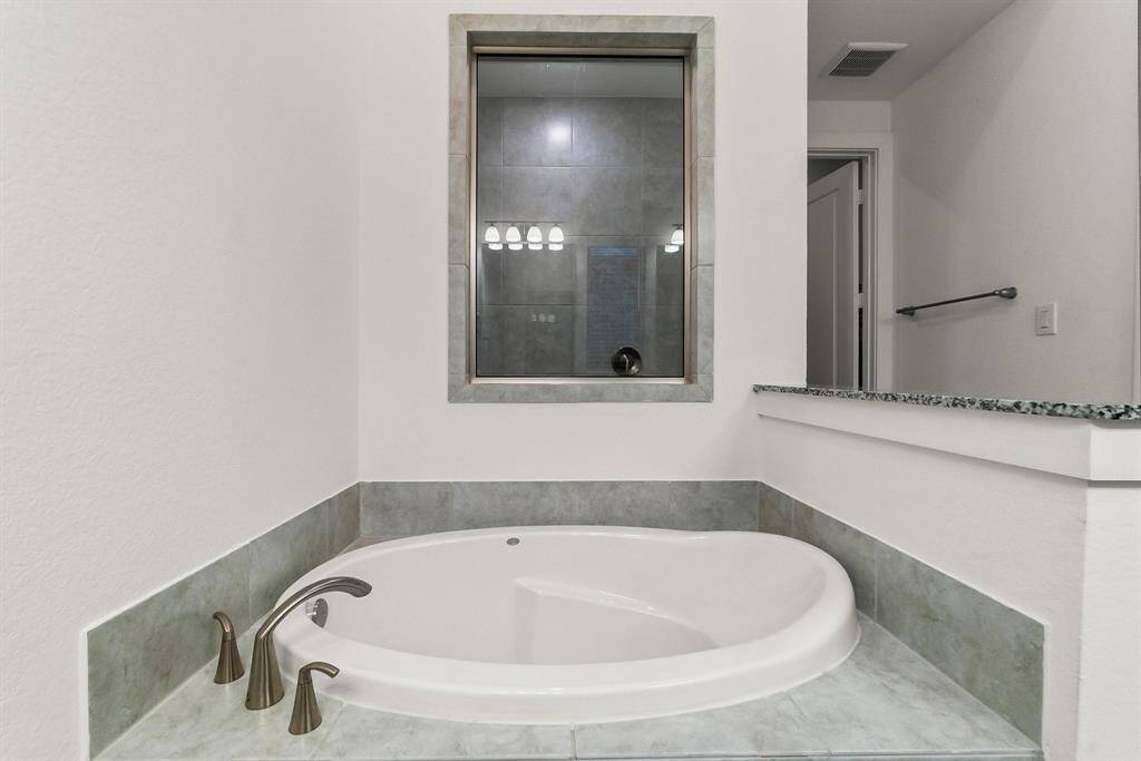 Unwind in the tastefully designed spa-like Owners’ bath. The soaker tub is ideal for relaxing, and the large tiled shower with built-in toiletry shelves is perfect for an invigorating wake-up in the morning.