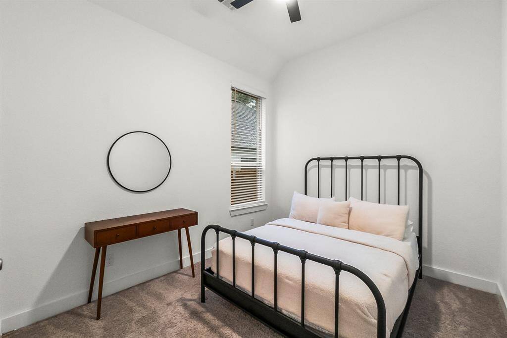 Another secondary bedroom offers lush carpet, walk-in closet, sunny window with blinds, and lighted ceiling fan. It has hallway access to a full bathroom shared with Bedroom 3.