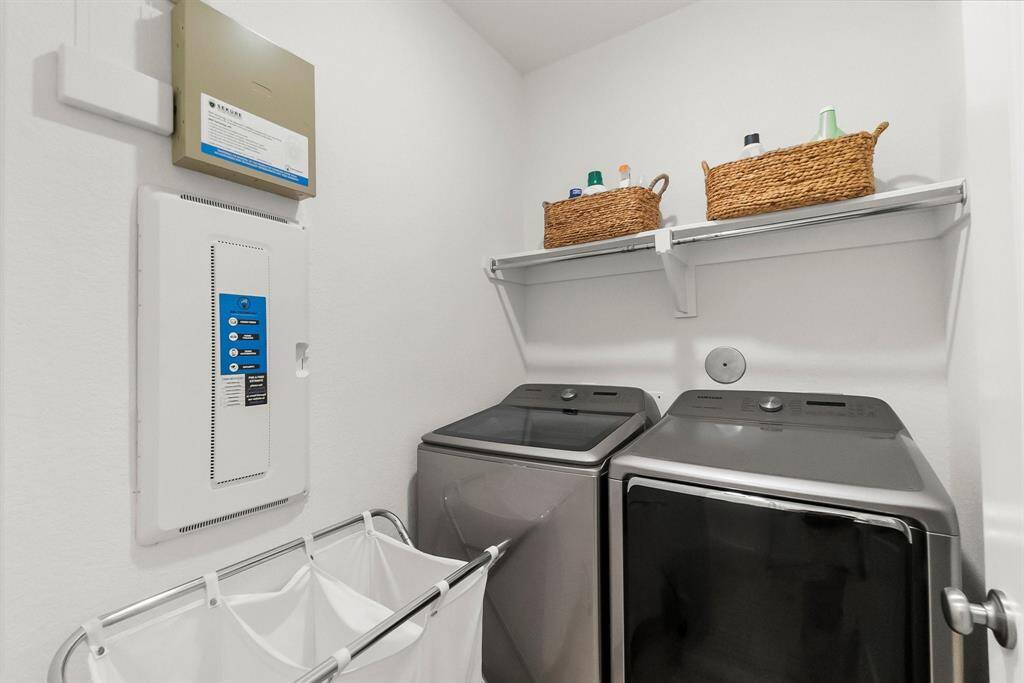 Large utility room features engineered wood plank flooring, overhead shelving, and a large hallway walk-in closet for storage of cleaning items and supplies. Washer and dryer are included!