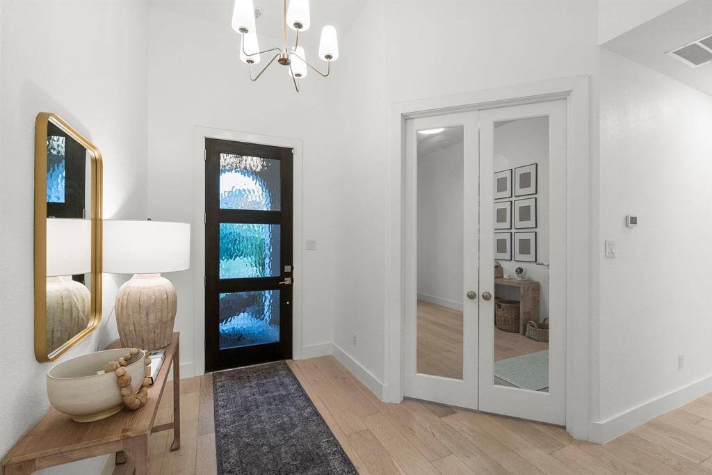 This custom-built home is thoughtfully designed with upscale upgrades and luxurious finishes at every turn—beginning with the show-stopping wood and glass front door that sets the tone for the elegance found throughout.