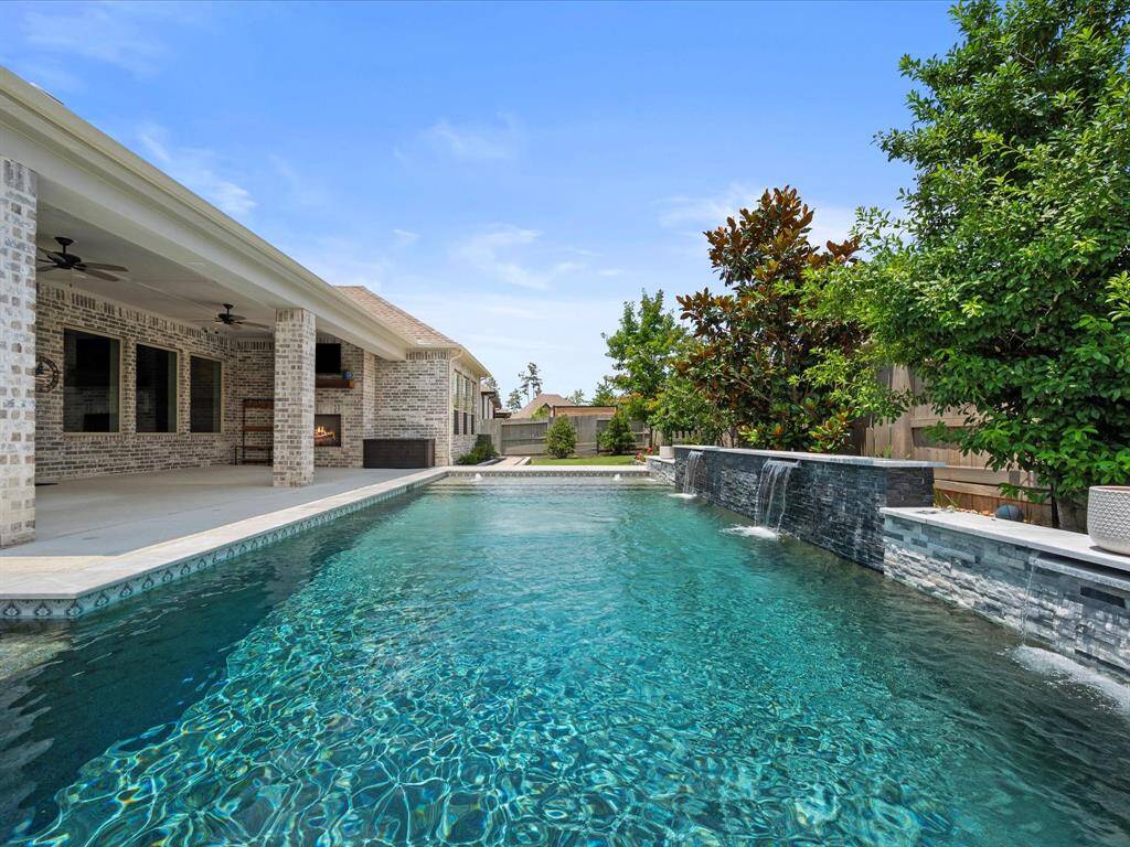 ENJOY YOUR BACKYARD OASIS ALL YEAR ROUND with this custom heated pool, covered rear patio w/ fireplace & additional electrical plug for a hot tub!