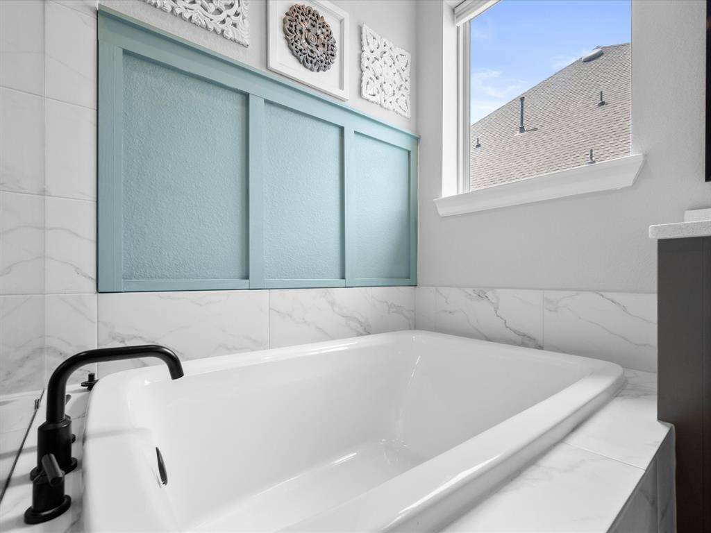 Carrying on from the Primary Bedroom, Board & Batten was customed added to the bathroom walls & above the soaking tub!
