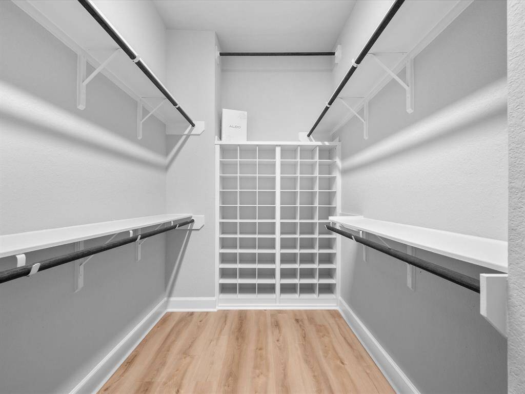 Storage is not an issue with this Primary WALK-IN CLOSET ROOM!  Custom shoe rack built-in, open shelving and ample space for all clothing.