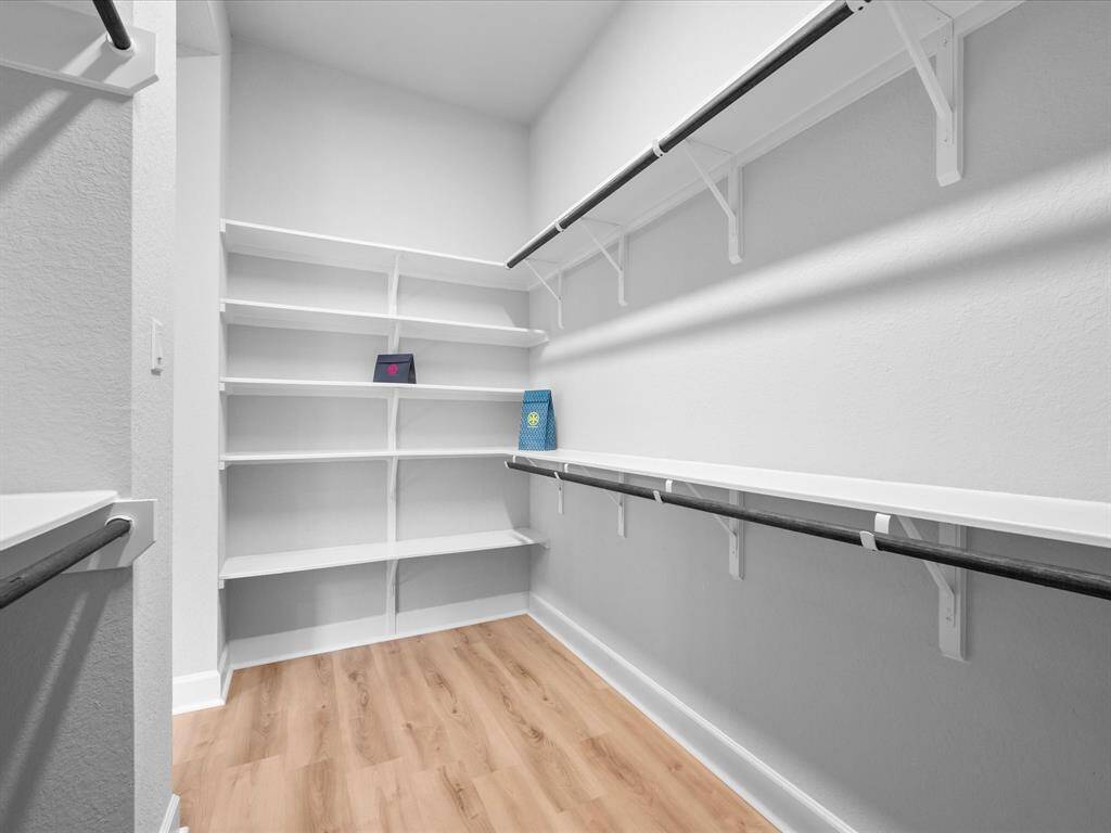 Storage is not an issue with this Primary WALK-IN CLOSET ROOM!  Custom shoe rack built-in, open shelving and ample space for all clothing.