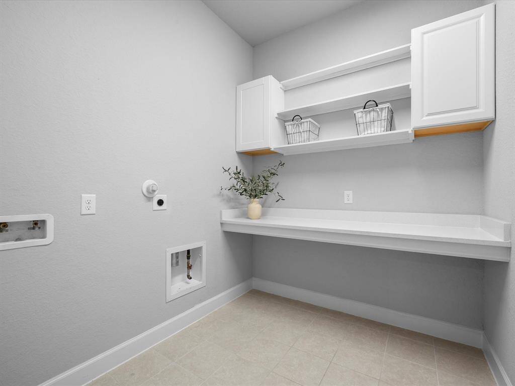 Utility Room off the garage with countertop & upper cabinetry added.  Gas & Electric Dryer Connections