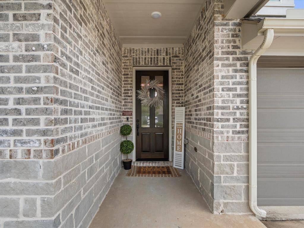 Step onto the front covered patio with upgraded 8' wooden door.  Constructed with modern gray stone & brick, the front patio is perfect for your new patio set watching the afternoon sunsets.