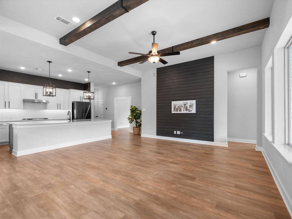 Centered in the Family, the custom accent shiplap wall ties together the tastefully done kitchen and vast Family Room space.