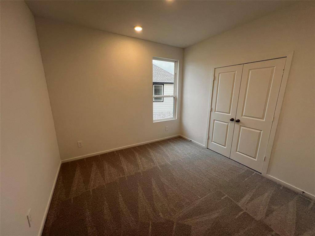 This comfortable upstairs bedroom offers a serene retreat with plush carpeting and ample natural light. Perfect for rest and relaxation, it's a private haven within the home.