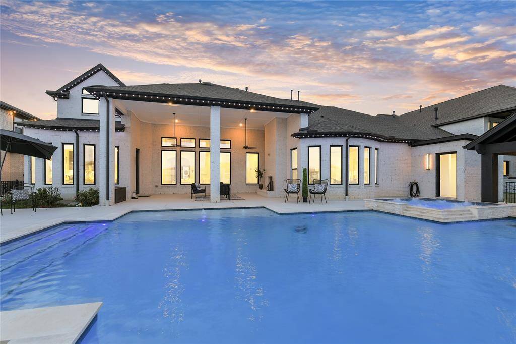 Resort-style backyard features a sparkling pool, spa retreat, and a covered lounge with accent lighting for day-to-night enjoyment.