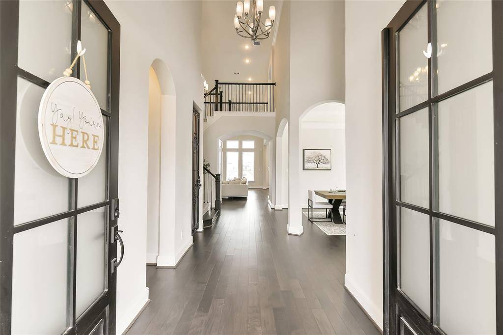 Glass & iron doors welcome guests into this grand entryway with view all the way to the lake and pool.  Note the beautiful flooring.