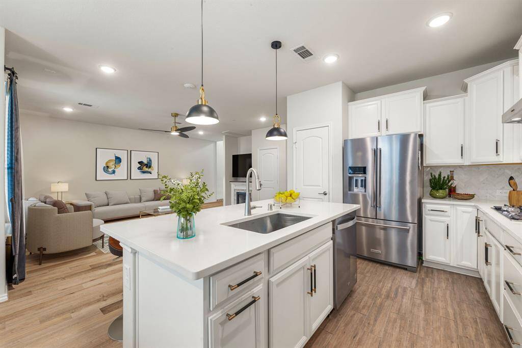 This stunning kitchen displays such a beautiful cultured marble countertops and white cabinets, custom neutral paint, light modern backsplash, and SS appliances, oversized kitchen island with extra storage, breakfast bar, recessed lighting, high ceilings and walk in pantry. *Virtually Staged2w