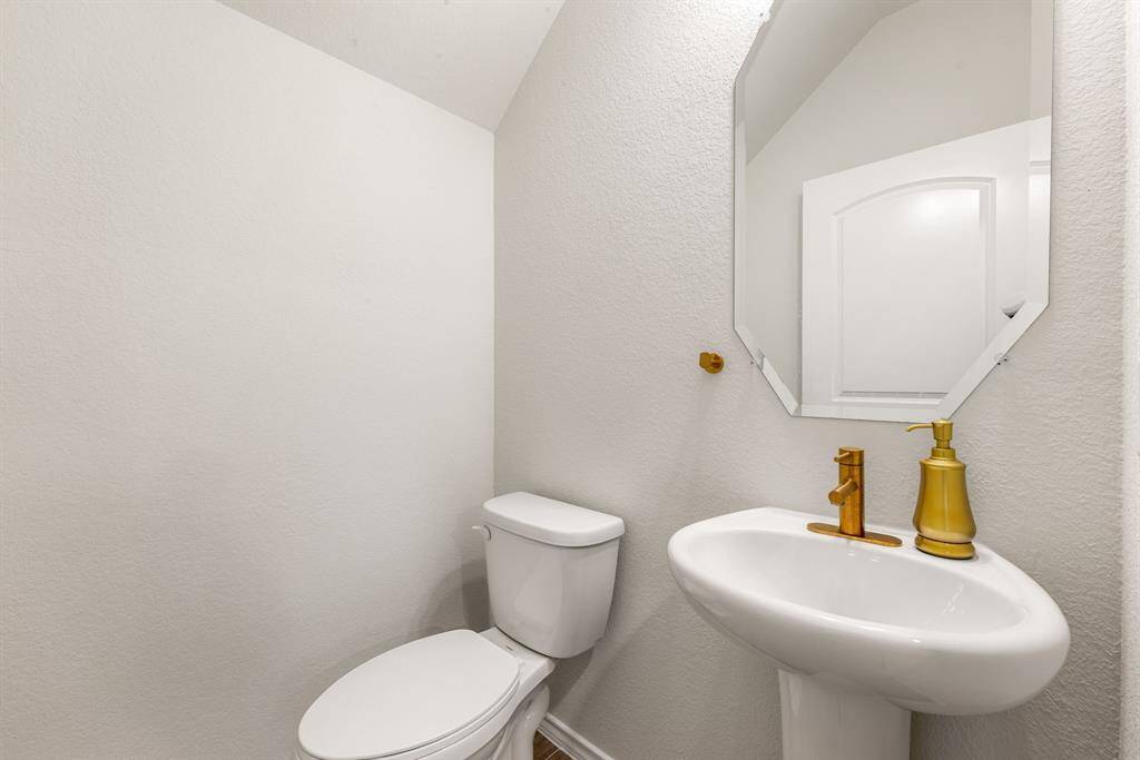 Stylish and convenient, this chic half bath showcases a sleek pedestal sink, modern fixtures, and designer touches, perfect for guests and everyday ease.