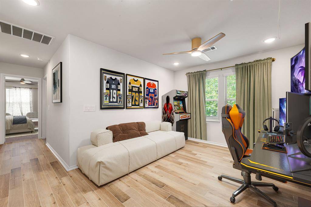 This bright and inviting room features large windows that allow for an abundance of natural light, creating a warm and welcoming atmosphere. The neutral wall tones and contemporary light fixture offer a modern yet versatile backdrop, while the spacious layout provides ample room for a variety of uses. With sleek hardwood flooring and stylish details throughout, this space is ideal for a home office, studio, or creative retreat.