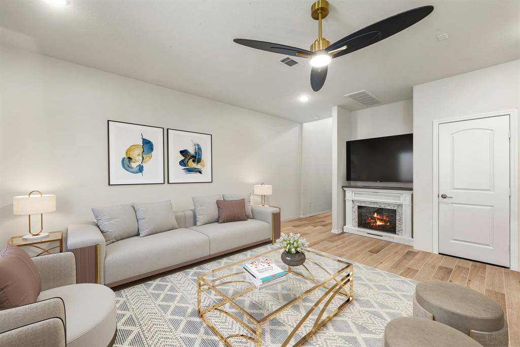 This living room is more like a GREAT room featuring a stunning fireplace with mantel detailing, custom paint, soaring high ceiling, recessed lighting, dark stained ceiling fan, and an amazing wall of windows providing a lovely view of your backyard to keep an eye out on the kids or pets playing. *Virtually Staged