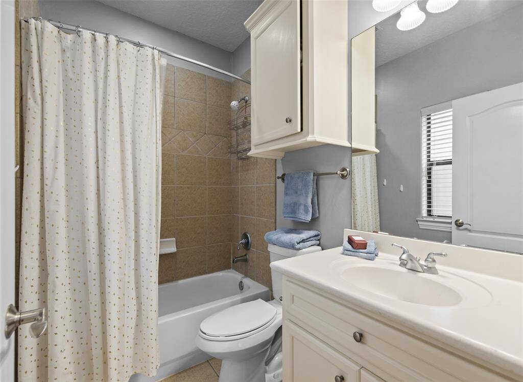 En suite full bathroom with plenty of storage