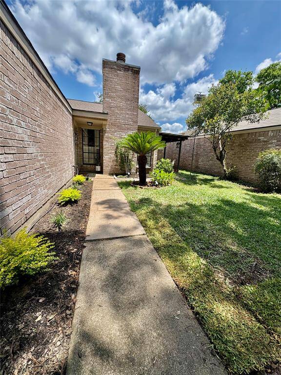Beautiful landscaped entrance to this charming gated home.