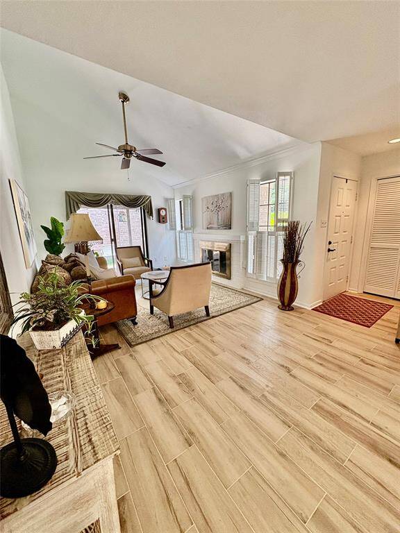 Another view of this beautiful living area showcasing the beautiful fireplace and windows with shutters. Light and bright fresh paint and new flooring.