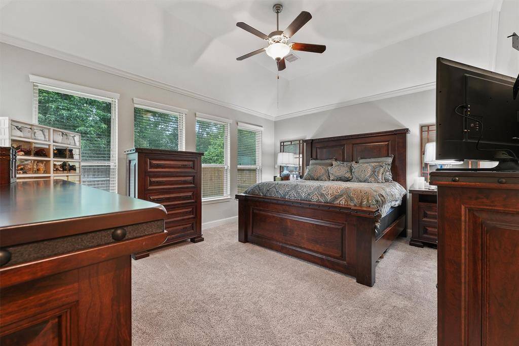 Primary bedroom with vaulted ceilings and a wall of windows