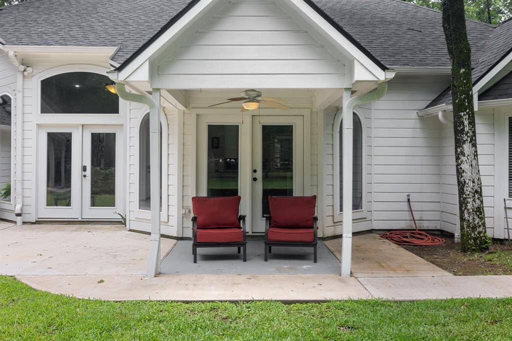 This photo features a charming backyard patio with a covered porch area ideal for relaxation or entertaining.