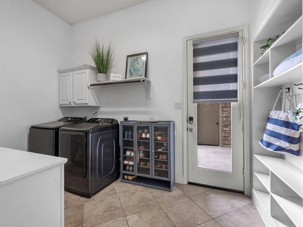 Oversized laundry room with mud room storage and folding table adjacent to W/D.