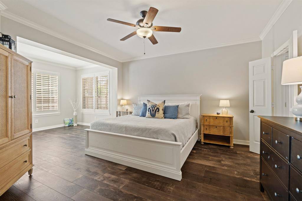 This good size bedroom features tile wood like flooring and large windows with shutters for natural light. It includes a cozy sitting area, overlooking the POOL/SPA with access to the ensuite bath area and large his/her walk-in closet space.
