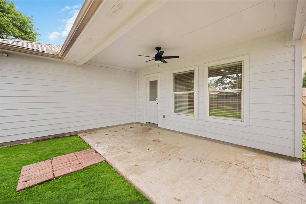Shade when you want it, style all the time—this covered patio with ceiling fan adds serious outdoor living value.
