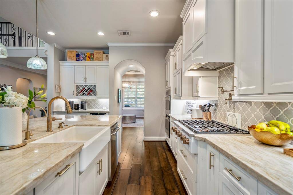A pro-style gas grill and top-notch appliances in this kitchen are made for preparing chef-inspired meals at home. The drawers below and a cabinet above the oven offer easy-access storage options for your cooking and baking supplies.
