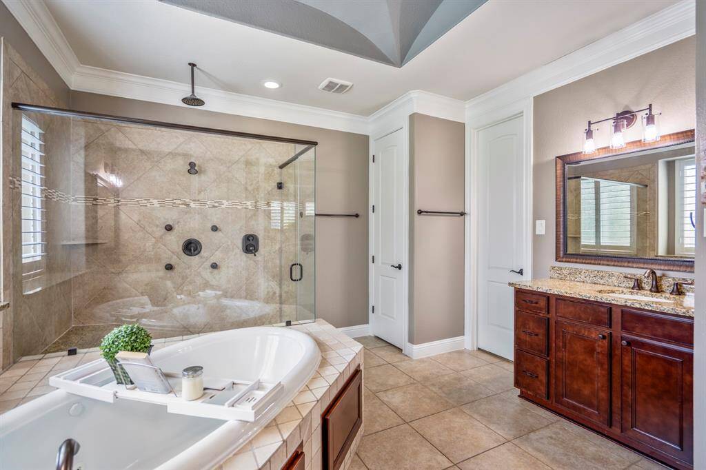 The spa-like en-suite bathroom offers a huge glass enclosed shower that features multiple head shower, including a rain shower.