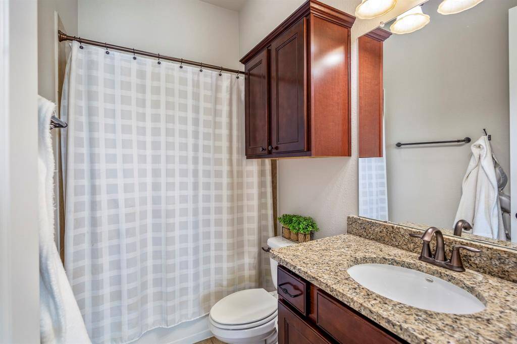 The second bathroom offers a tub / shower configuration, with granite countertop on the vanity.
