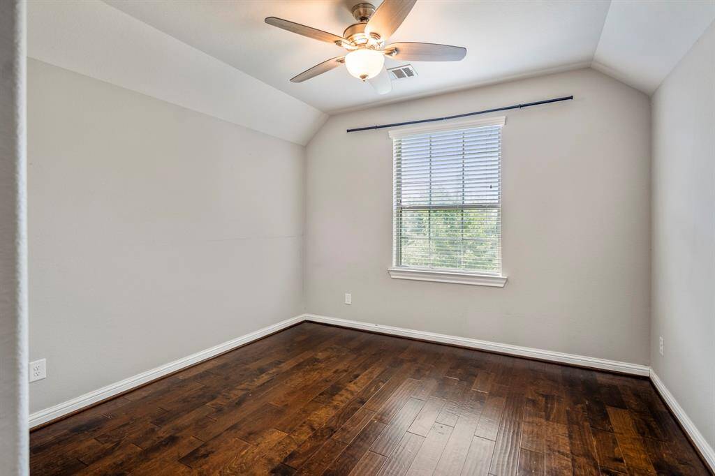 The fourth bedroom which is upstairs has neutral tones, a nice size closet and window and angled ceiling.