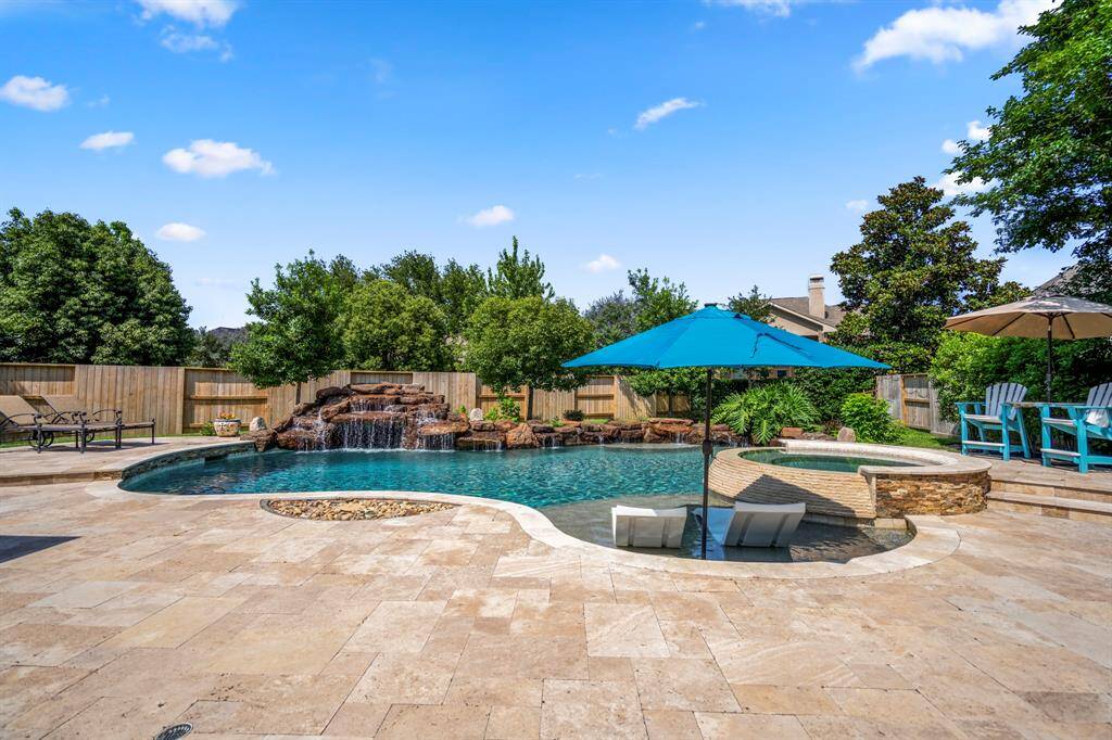 The backyard offers a natural aesthetic that complements the sparkling pool, spa and rock waterfall, the earth tones look particularly gorgeous under the Texas sky.