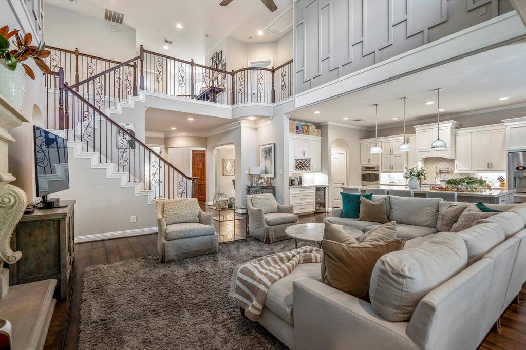 The exceptional millwork, ornate wrought iron railings of the staircase in the family room create a dramatic focal point.