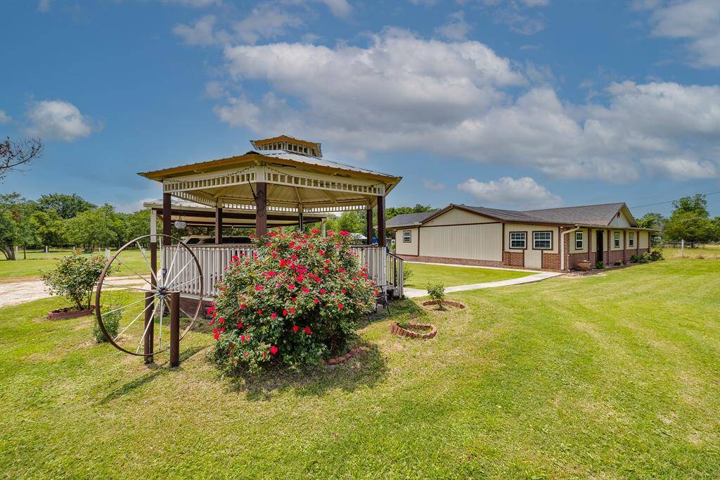 Charming gazebo with blooming roses and country charm—perfect for relaxing evenings or entertaining under the Texas sky.