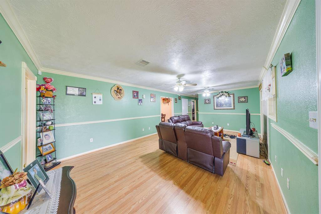 Comfortable main living area with two ceiling fans and leather seating—ideal for movie nights or gatherings.
