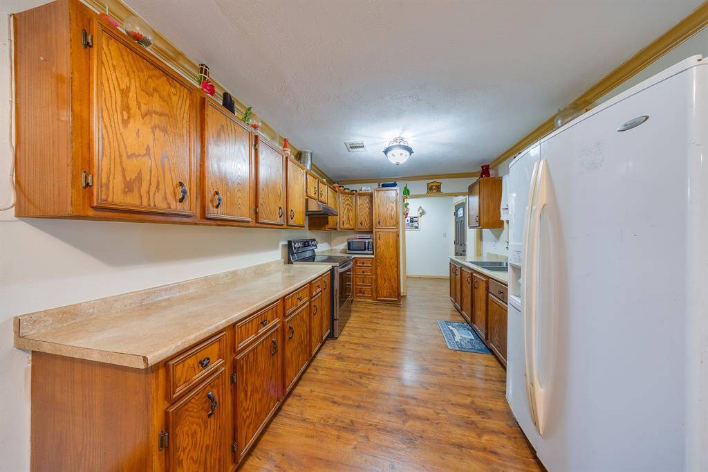 Extended kitchen view shows dual countertops and generous cabinetry—designed to maximize storage and workspace.