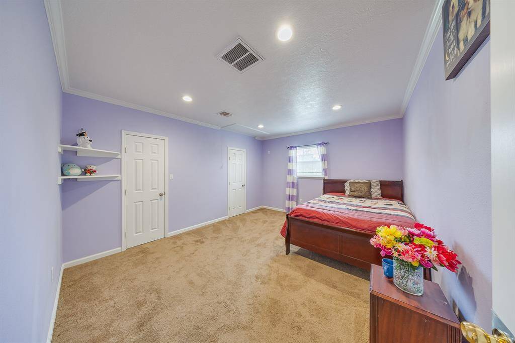 Oversized bedroom with crown molding, plush carpet, and recessed lighting—ideal for restful nights or a flex space.