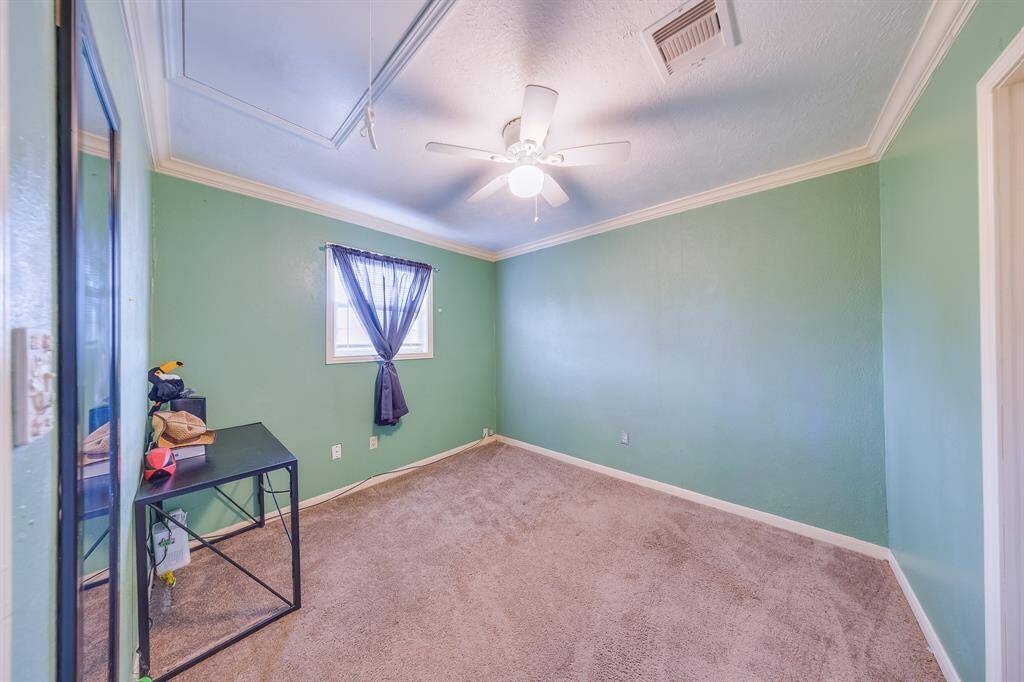 Spacious secondary bedroom with ceiling fan and natural light—blank canvas ready for your personal touch.