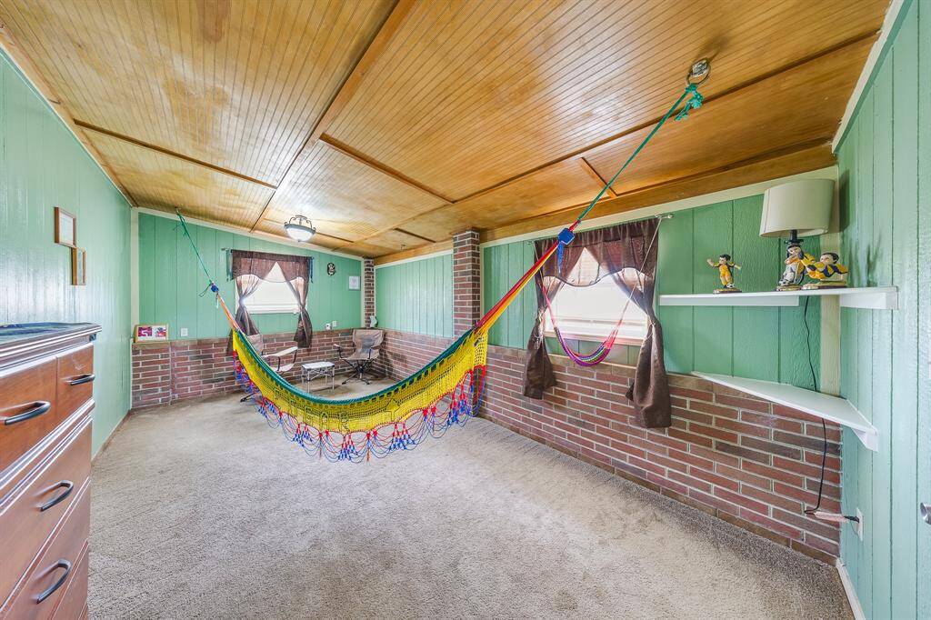Versatile bonus space with brick accents and ceiling detail—enjoy it as a sunroom, gym, or hobby room.
