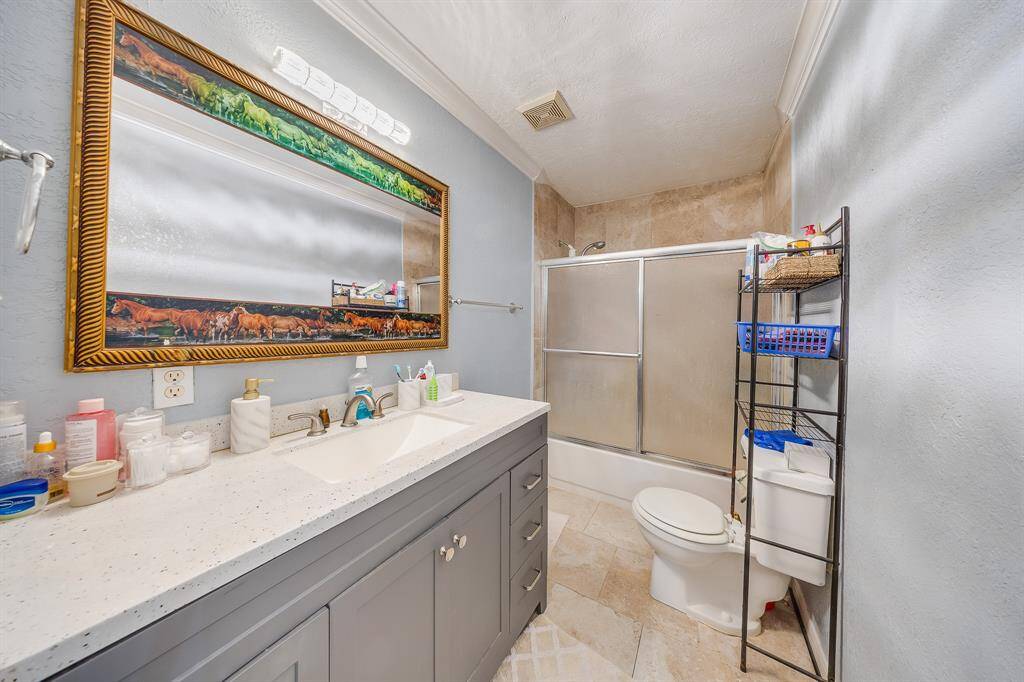 Full bathroom with updated lighting, oversized mirror, and charming tile floor—move-in ready and well-kept.