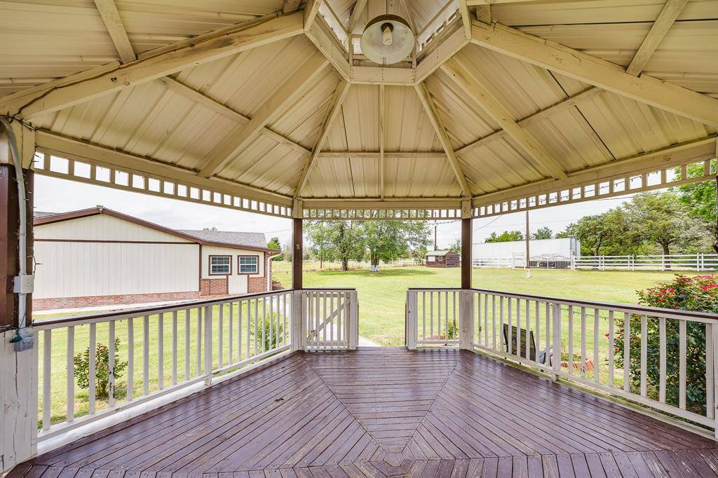 Enjoy scenic views and fresh air from this spacious covered gazebo overlooking lush, peaceful acreage.