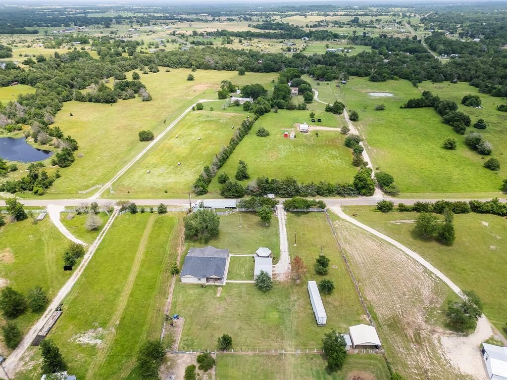 Zoomed-out aerial shot offering a scenic view of the neighborhood and countryside.