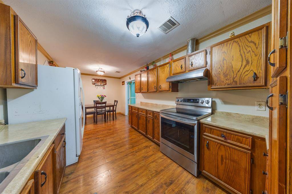 Galley-style layout with stainless appliances and breakfast area—functional and inviting with a cozy home feel.