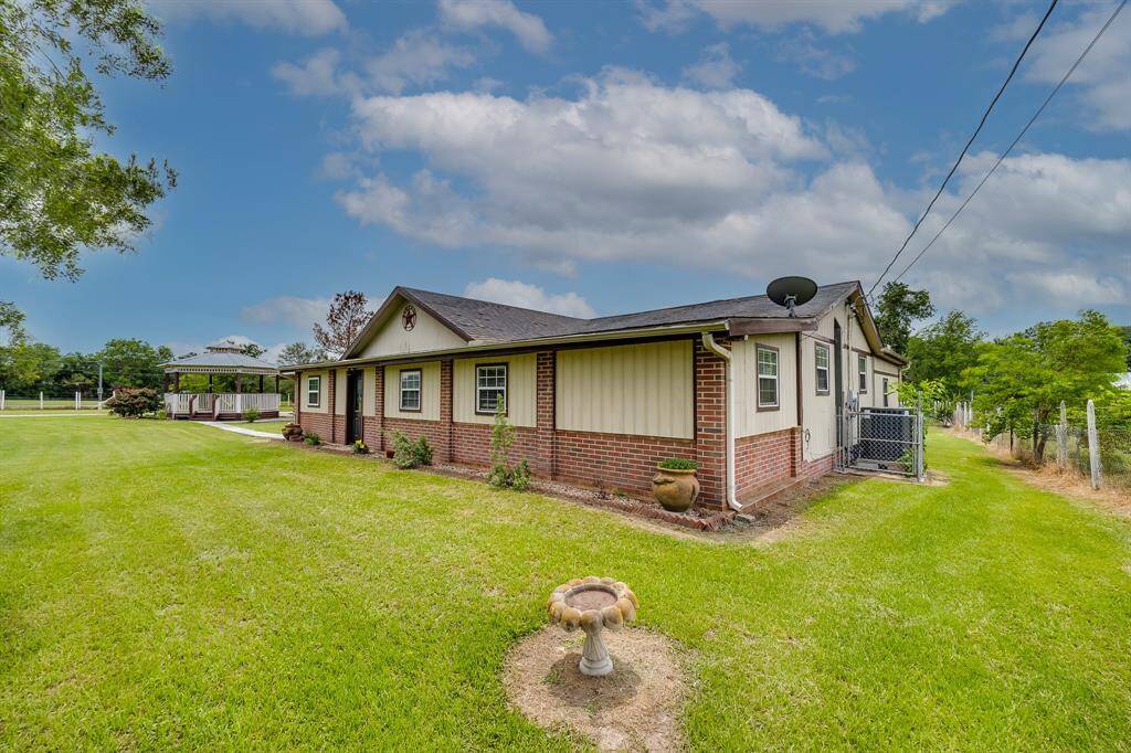 Inviting front view with a mix of brick and siding, lush grass, and welcoming curb appeal.