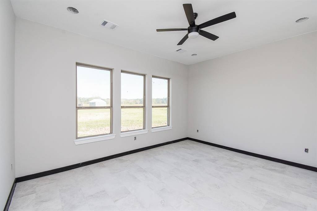 Primary Bedroom has lots of natural lighting with a view to the acreage out back.