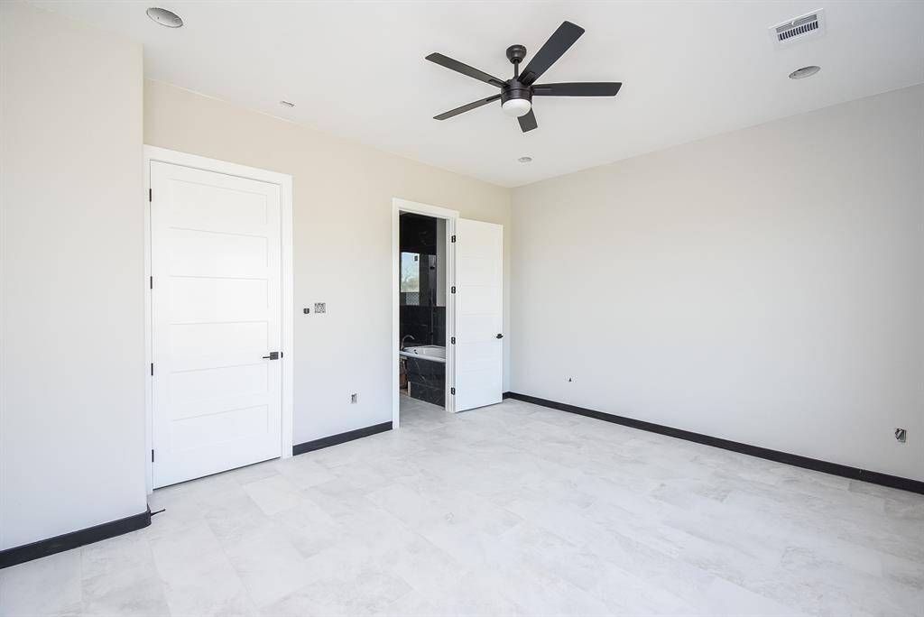 Primary Bedroom has lots of natural lighting showing entry to primary bath