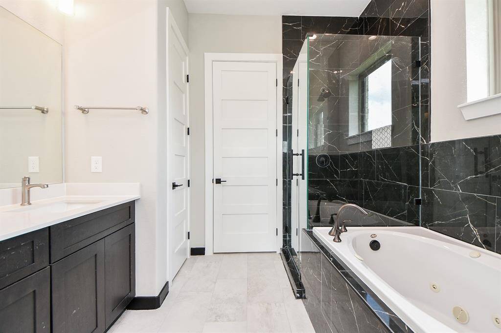 Primary Bath has Spa tub, large shower with floor to ceiling tiling!