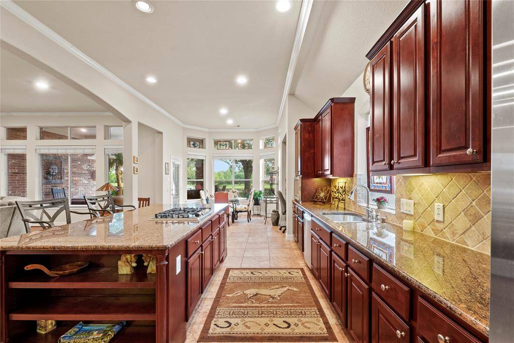Cooking is a breeze with loads of prep space and an amazing layout. A stone backsplash and complementary granite countertops give a cohesive feel in this gourmet kitchen.